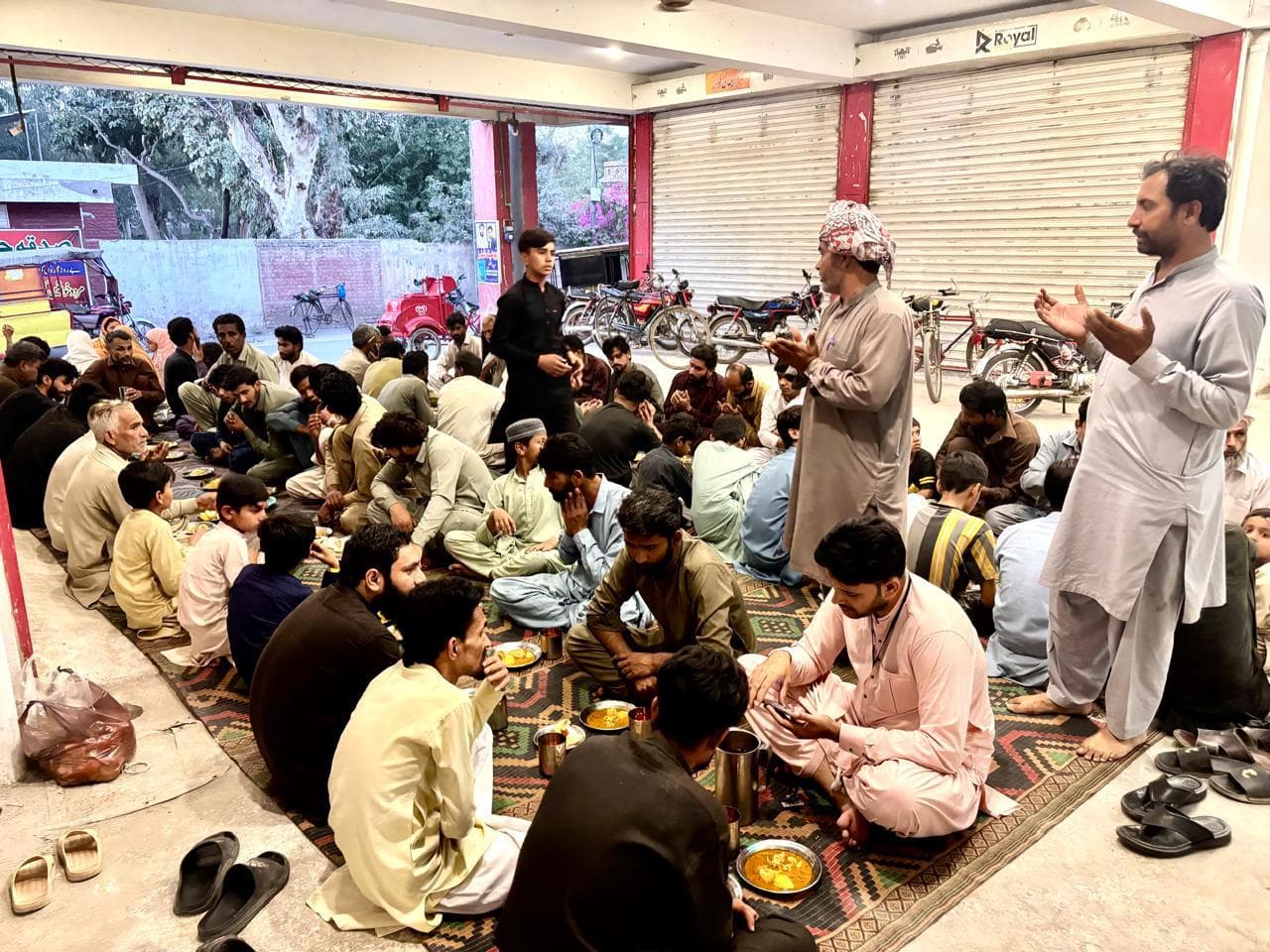 Ramadan iftaar program with people seated for dua and meal service
